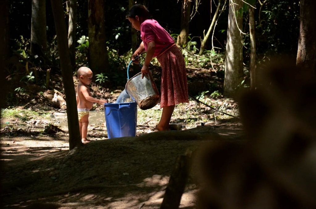 Mulher Huni Kuin  retira água do poço no Parque Ambiental de Plácido de Castro. (Foto: Odair Leal/AmReal)
