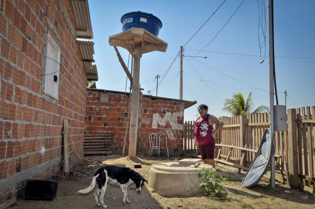 A moradora Maria Izelda da Silva paga para encher a caixa d´água (Foto: Odair Leal/Amazônia Real)