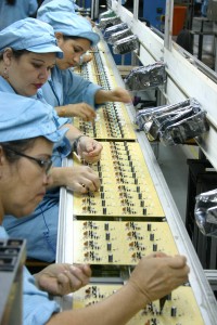 Funcionárias montam componentes de placas em fábrica de Manaus (Foto: Alberto César Araújo)