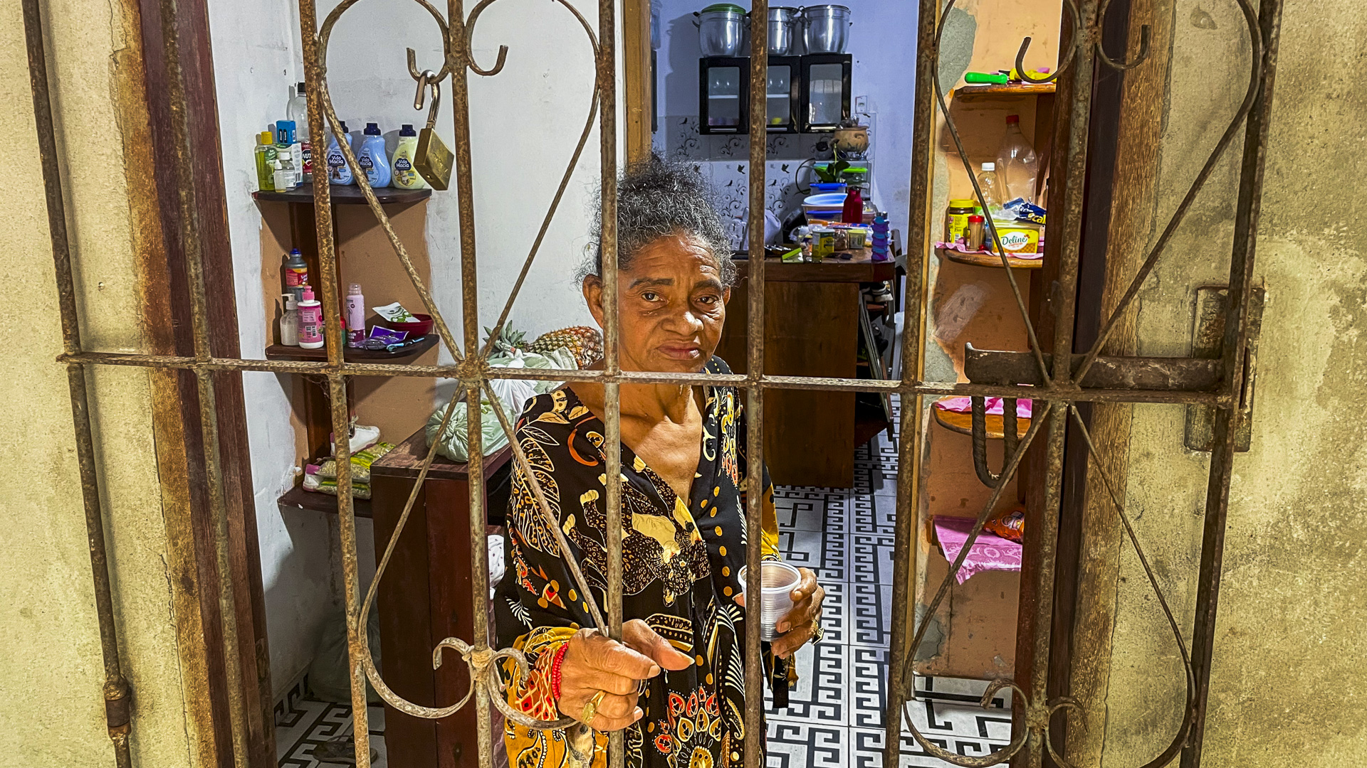 Dona Socorro de Burajuba em um dos 14 portões que fecham a sua casa (Foto: Giovanny Vera/Amazônia Real/2025).