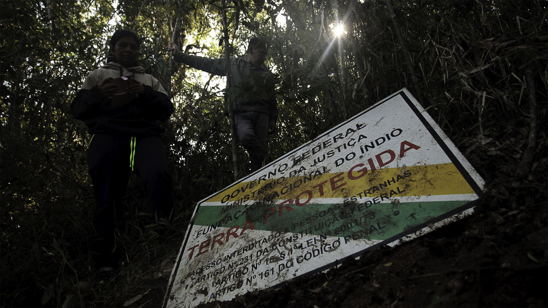Indígenas do povo Xokleng na Terra Indígena Ibirama-Laklãnõ, em Santa Catarina mostram placa de área protegida que foi derrubada pelos invasores (Foto: Lucas Amorelli/Amazônia Real/2023).
