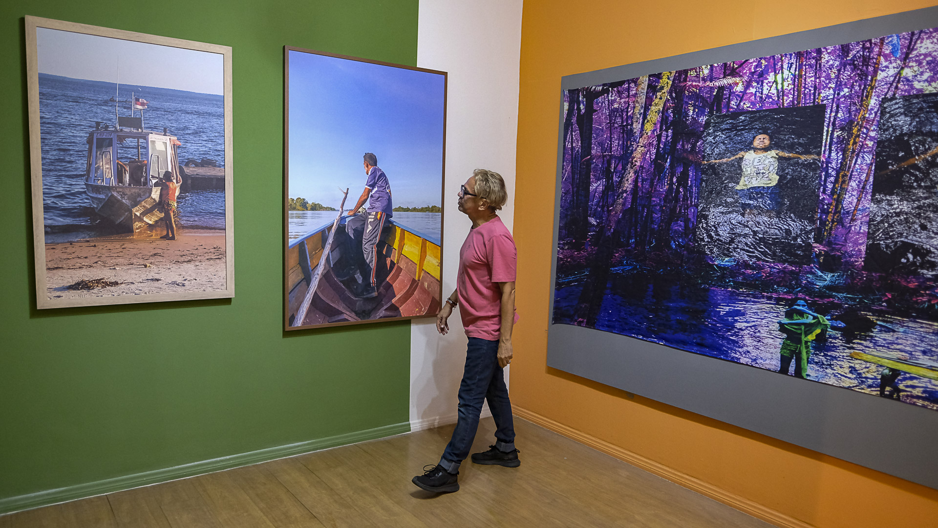 O curador da Galeria do Largo, Cristóvão Coutinho, observa as obras de Juliana Pesqueira e Margem do Rio (Foto: Alberto César Araújo/Amazônia Real).